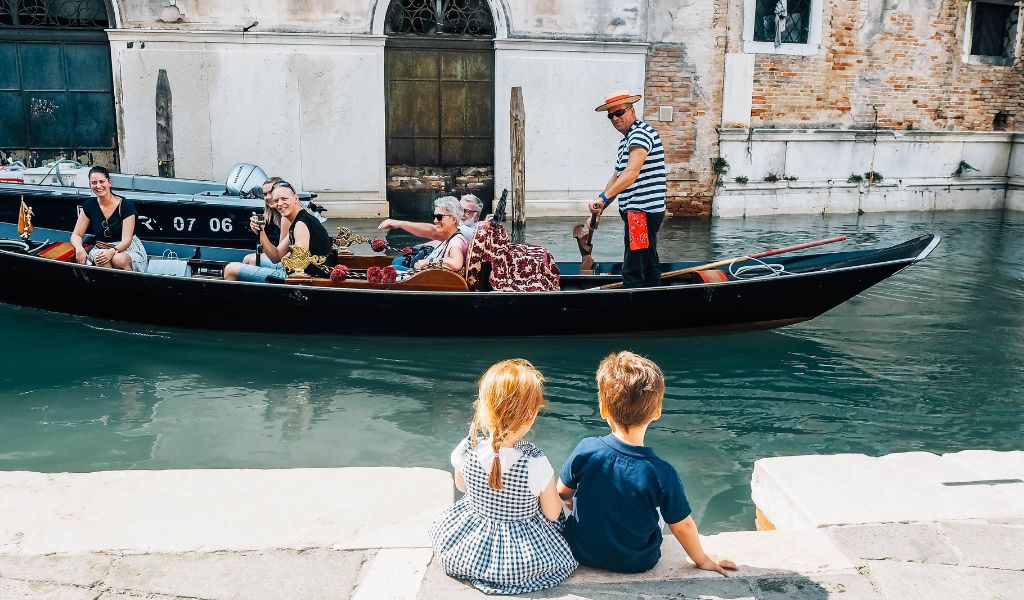 kids watching a gondola in venice