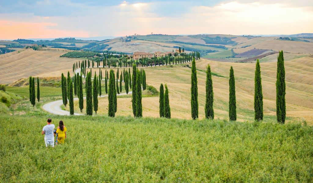 couple walking through a field in the italian countryside